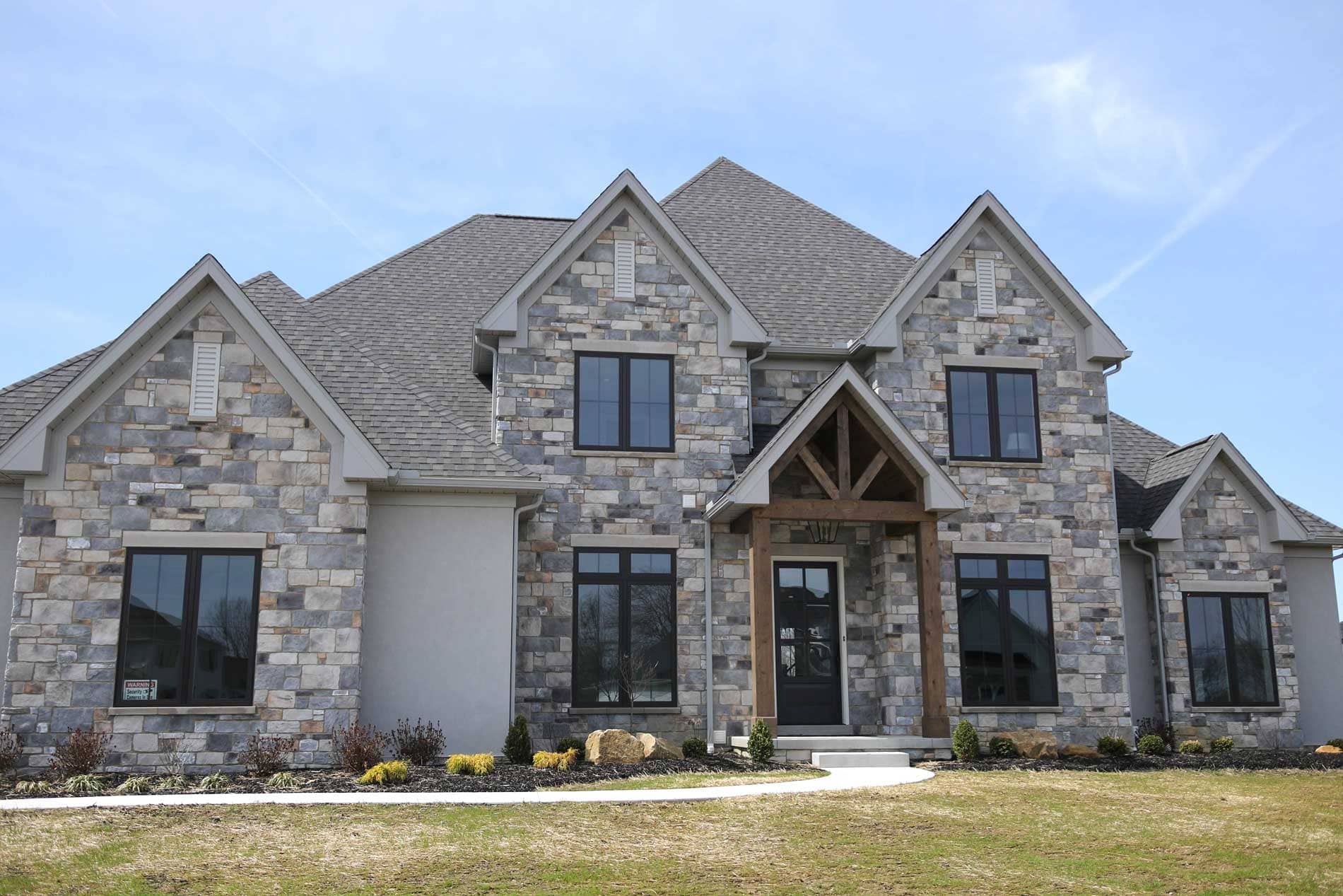 An exterior of a home featuring Casa di Sassi Volterra stone veneer.