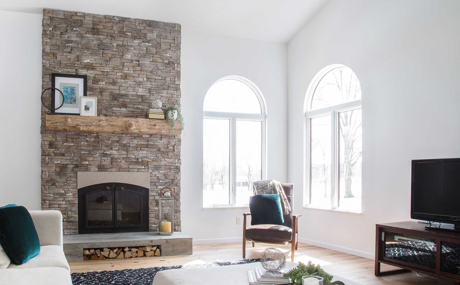 Living room with a fireplace, featuring Casa di Sassi's Matera Kwik Stack stone veneer.