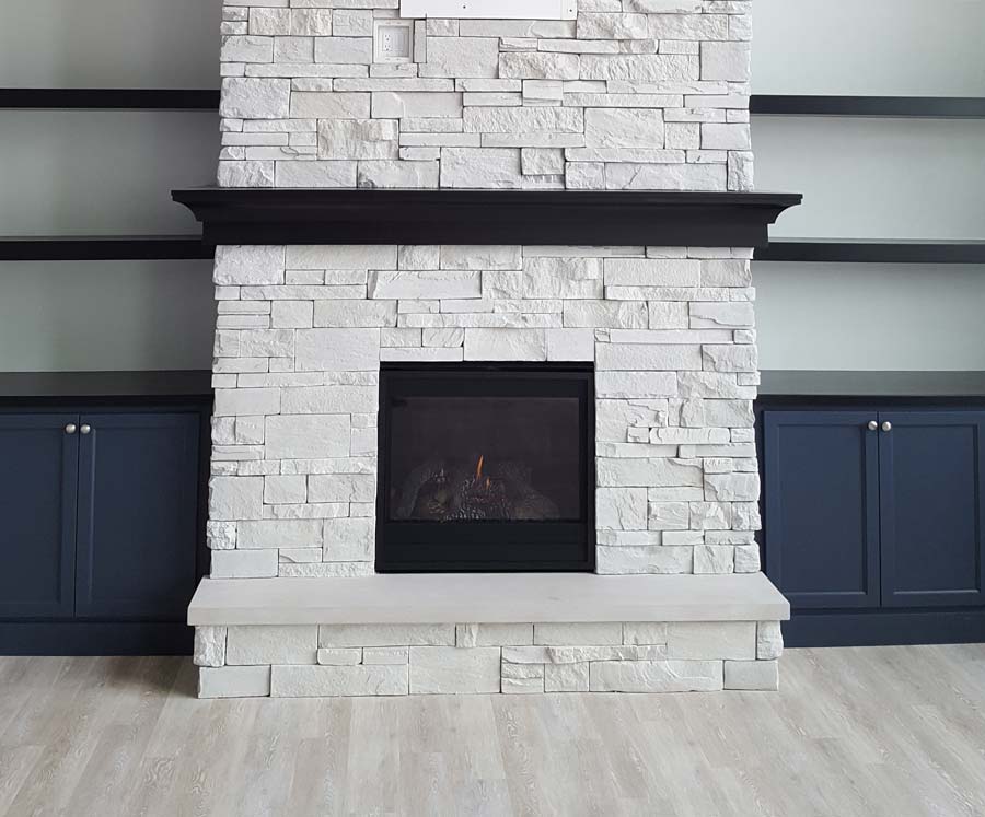 White stone veneer fireplace with a black fireplace mantel