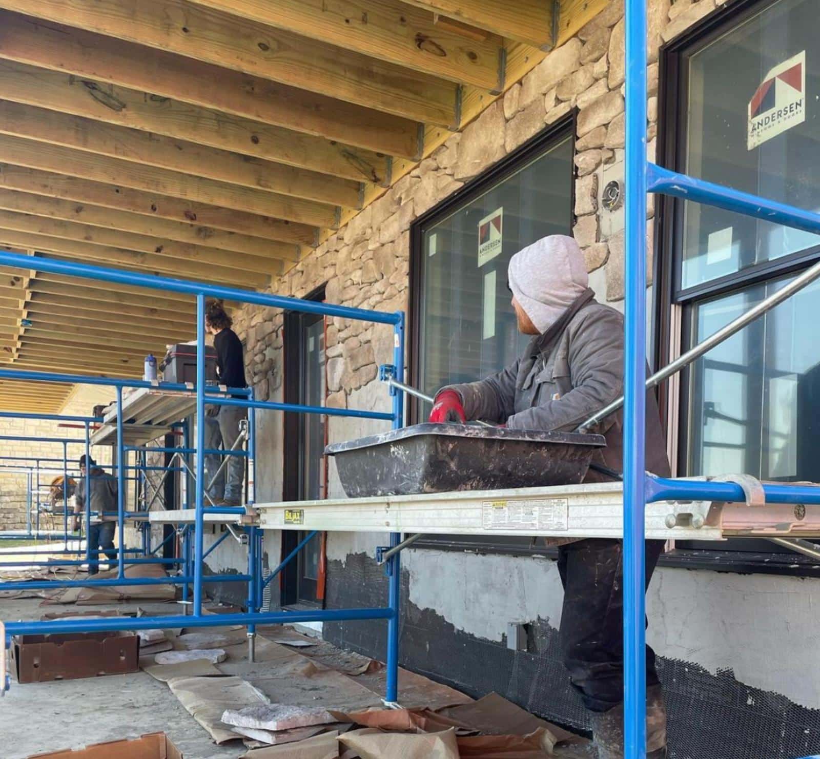 professional installers working to add stone veneer to home exterior